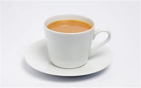 a white cup and saucer , the cup contains tea