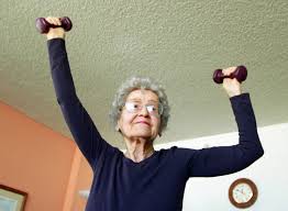 this image shows an elderly lady exercising with hand weights