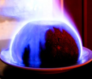 a flaming christmas pudding with a blue flame engulfing most of it