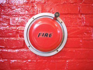 a red brick wall with a fire alarm on it