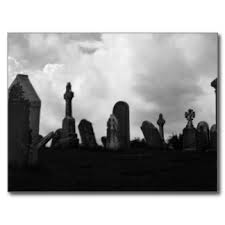 an eery black and white photo of gravestones against a cloudy sky.