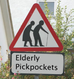 a red triangle road sign with a elderly man and woman in it . underneath it reads elderly pickpockets
