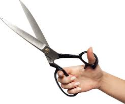 this image shows a hand holding a pair of scissors