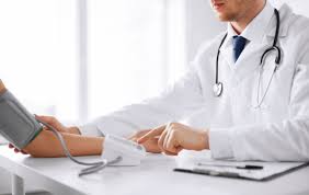 white coat syndrome. this image shows a doctor in a white coat taking someones blood pressure.