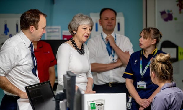This image shows the Prime Minister Mrs May and NHS staff in a hospital ward