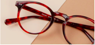 This image shows a pair of reading glasses with an attractive round frame. They are reddish brown in colour