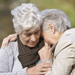 Depression and anxiety is common in older adults. This image show an elderly woman being comforted by another elderly woman