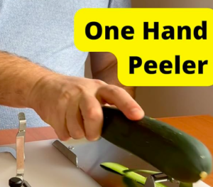 Preparing food with one hand. This image shows a food preparation aid. It is a white board with different stainless steel securing clamps. In this photo it shows someone single-handedly peeling a courgette.