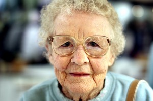 elderly lady with a wrinkled face and glasses not smiling
