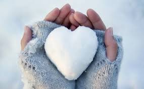 this image shows a pair of hands with grey fingerless gloves holding and ice heart