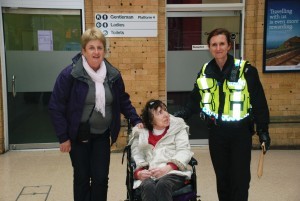 this image shows 3 women. one police officer and a woman in a wheelchair