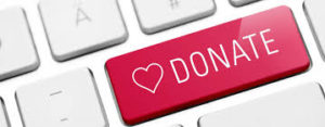 this image shows a donate button on a key board. The button is pink and has a heart on it.