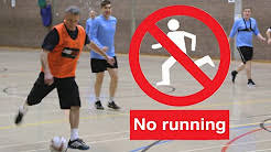 this image shows an indoor football game and a red circle with a running man inside and a sign saying no running