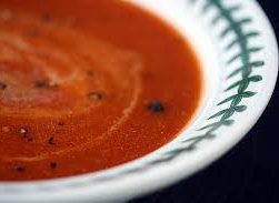 this image shows a white bowl containing tomato soup