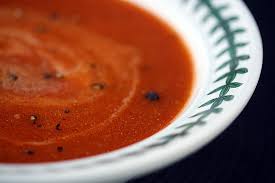 this image shows a white bowl containing tomato soup