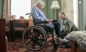 This image shows a daughter with her Mum who is in a wheelchair following a stroke
