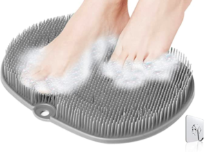 This image shows a pale grey foot scrubber. It has soft rubber bristles that you add shower gel to and rub your feet over it to wash them