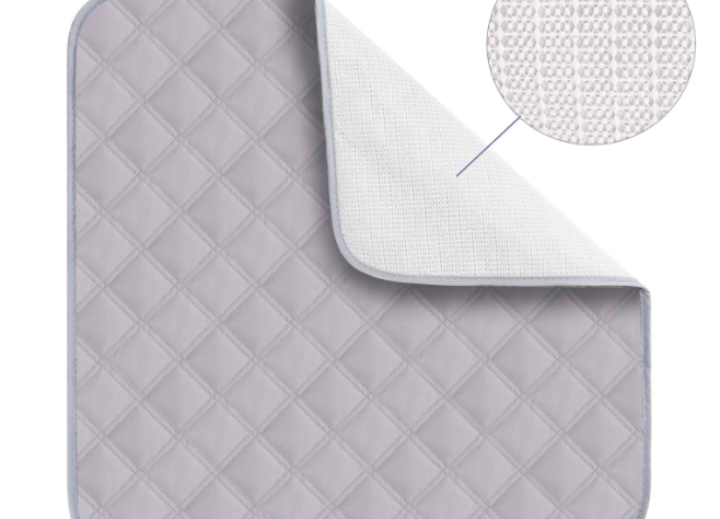 This article cvoers waterproof Seat Pads. The image shows a square, pale grey pad. It has diamond shaped quilting on it and the top right-hand corner is folded over to show the white non-slip underneath.